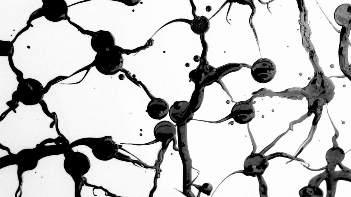 High contrast abstract art capturing black ink forming intricate patterns on a white backdrop.