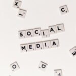 Flat lay of letter tiles spelling Social Media with scattered white tiles on a surface.