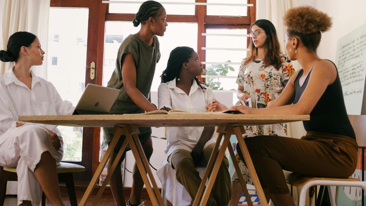 A diverse team of women brainstorming ideas in a modern office setting, fostering collaboration and creativity.
