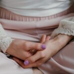 A woman in elegant lace attire practicing meditation in a calm indoor setting.