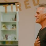 A happy retiree celebrates his retirement with a heartfelt smile indoors.