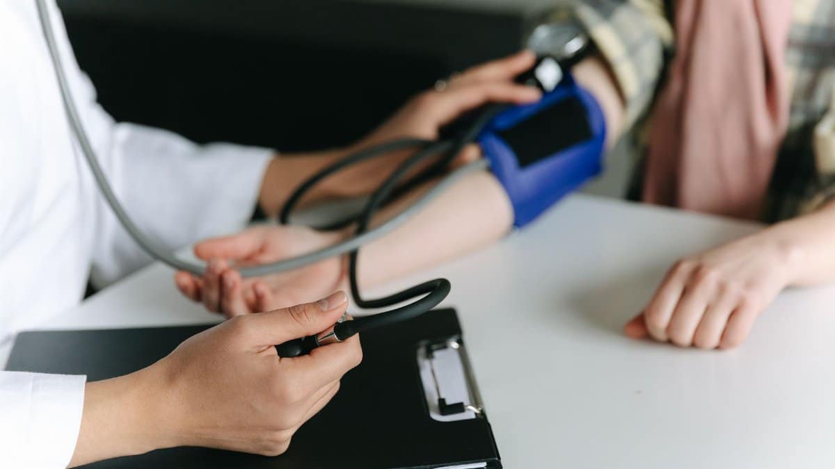 Close-up of a medical professional measuring a patient's blood pressure at a clinic.