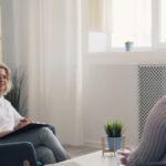 A therapist and a client engaging in a counseling session in a bright, modern office.
