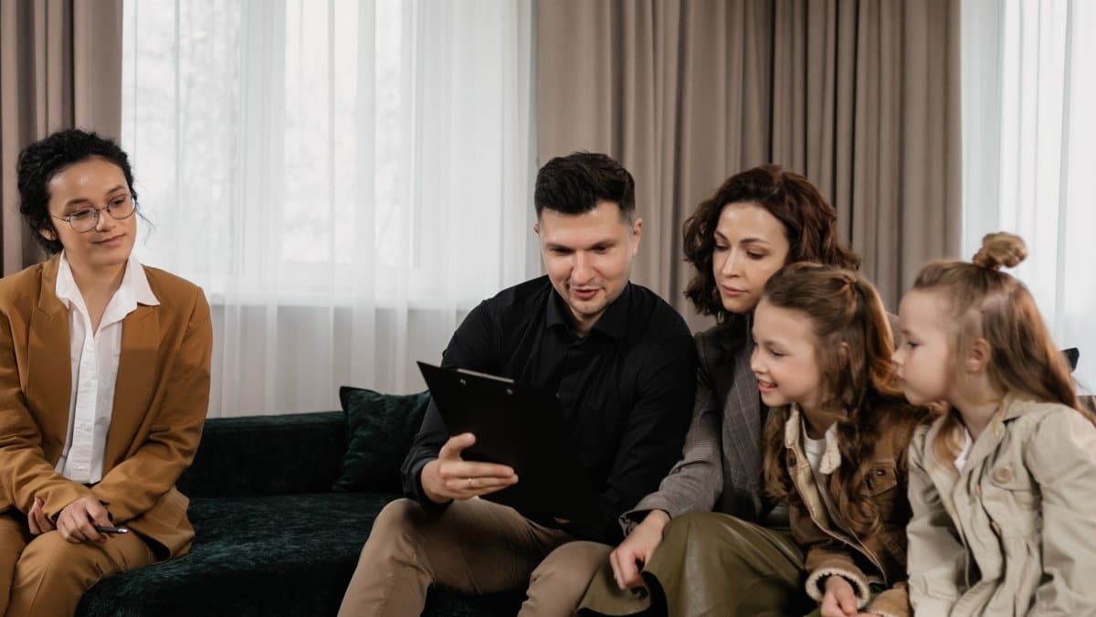 A family receiving advice from a professional advisor indoors, focused on financial planning.
