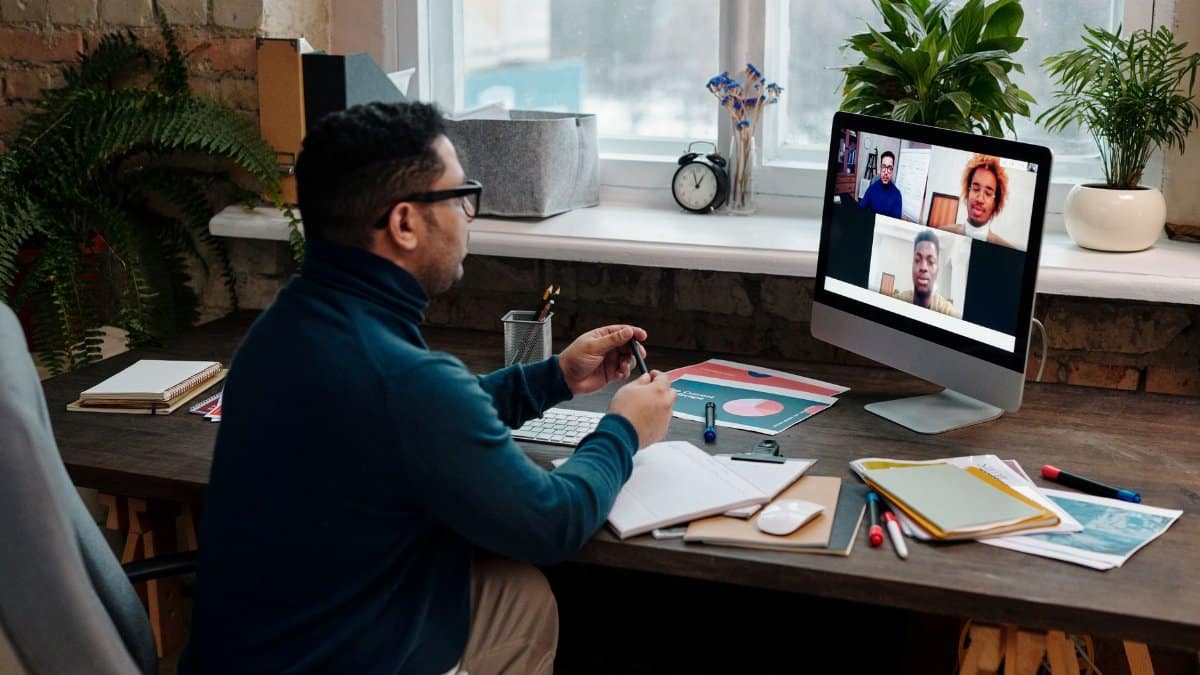 Man engaging in an online meeting from home office, showcasing remote work dynamics.