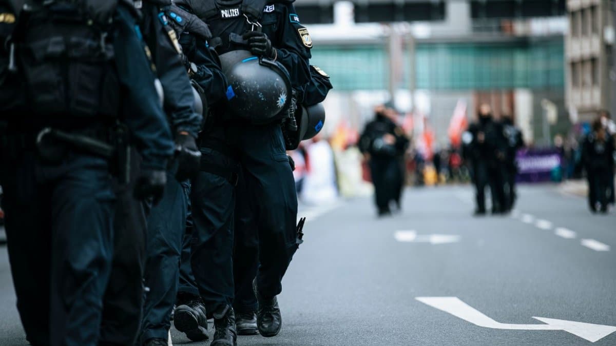 A line of police officers in uniform marching during a city protest, showcasing solidarity.