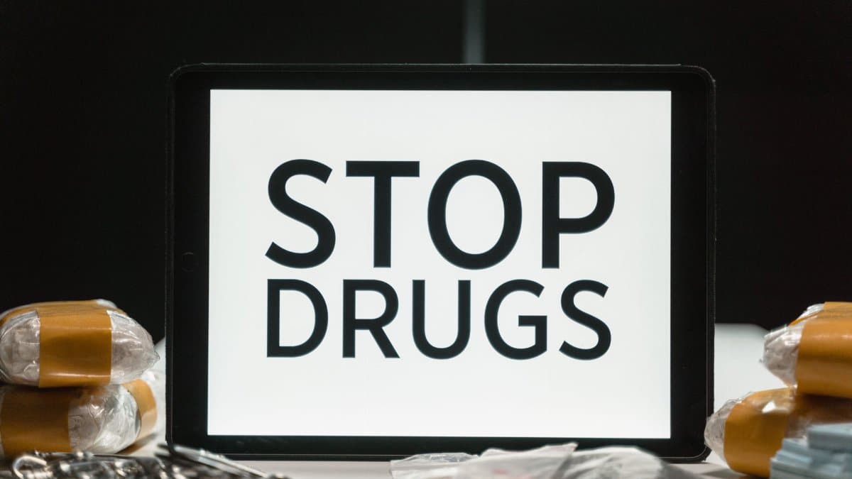 Tablet screen displaying anti-drug message surrounded by packaged substances, promoting awareness.