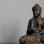 Elegant bronze Buddha statue representing peace and spirituality in meditation setting.