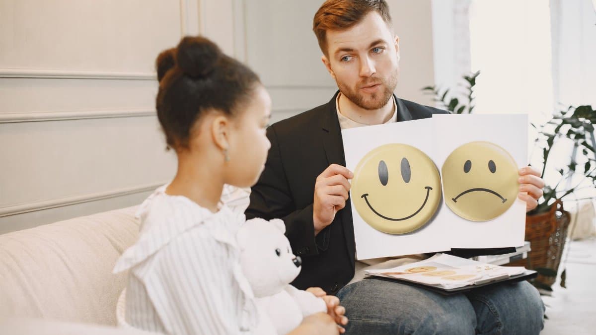 A therapist uses emotion cards to help a child express feelings during a counseling session.