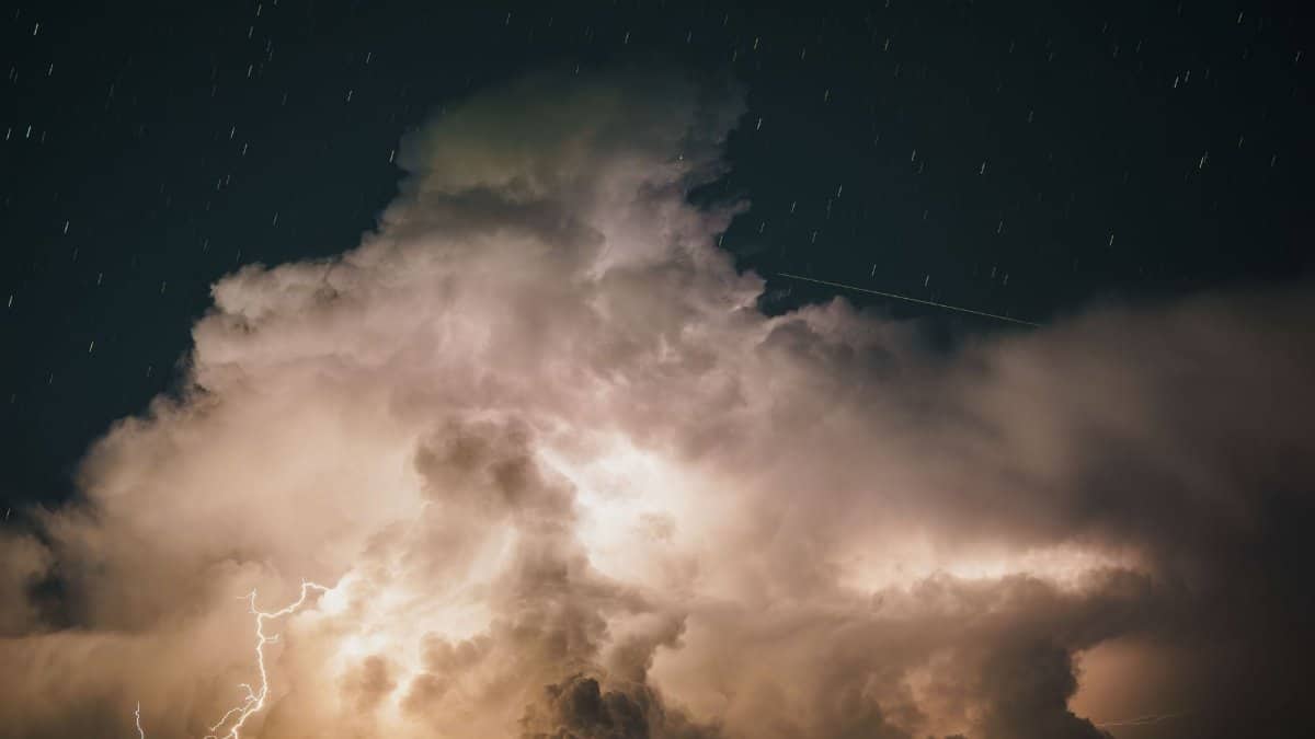 A captivating night sky with dramatic lightning illuminating large thunderstorm clouds.