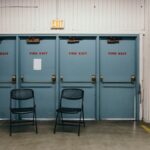 Industrial setting featuring three blue fire exit doors and two black chairs in a Portland warehouse.