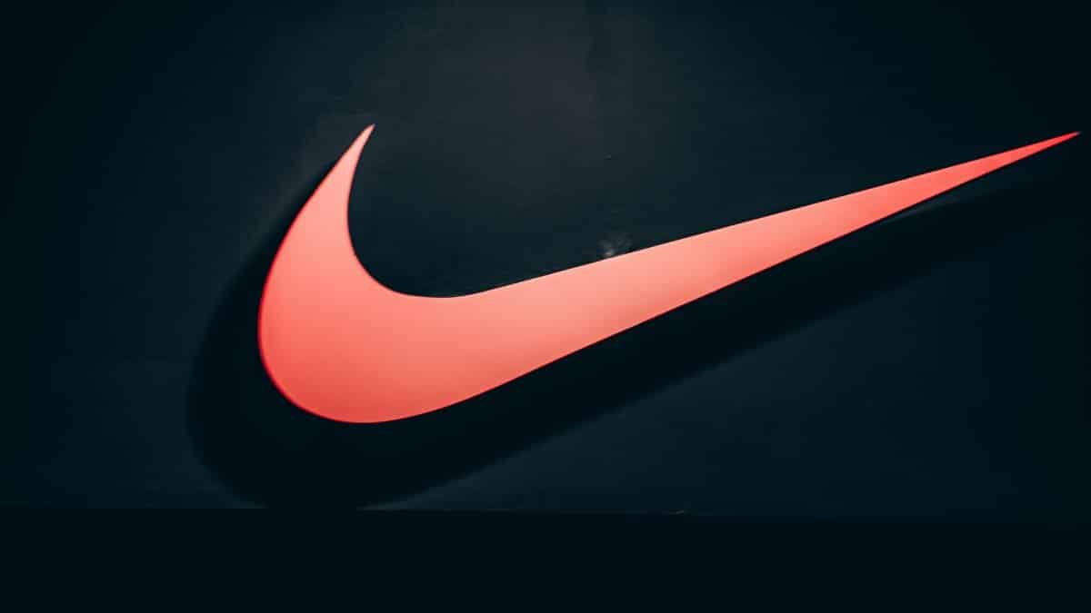 Vibrant red Nike swoosh logo displayed on a dark, minimalist backdrop symbolizing sports and lifestyle.