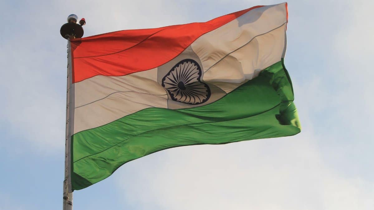 The Indian national flag flies proudly against a clear blue sky, showcasing national pride.