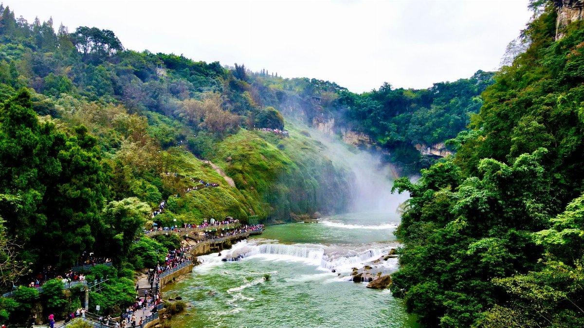 Spectacular view of Huangguoshu Waterfall surrounded by lush forest in Guizhou, China.