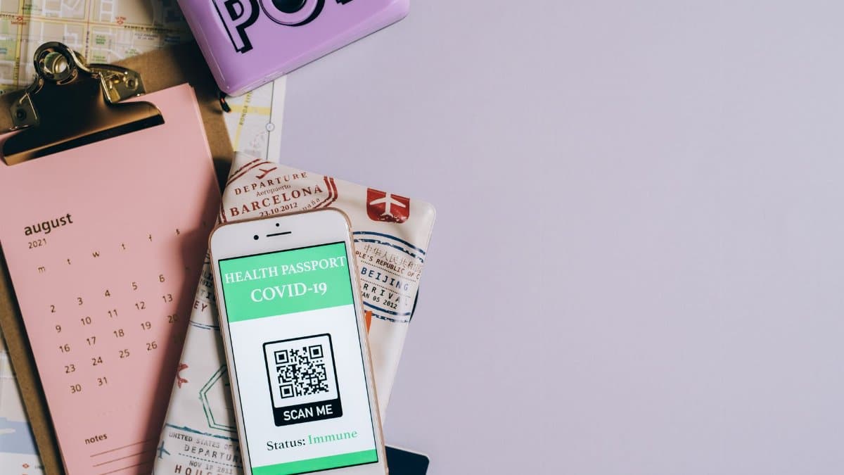 Flat lay image of a health passport with a COVID-19 QR code, calendar, and map.