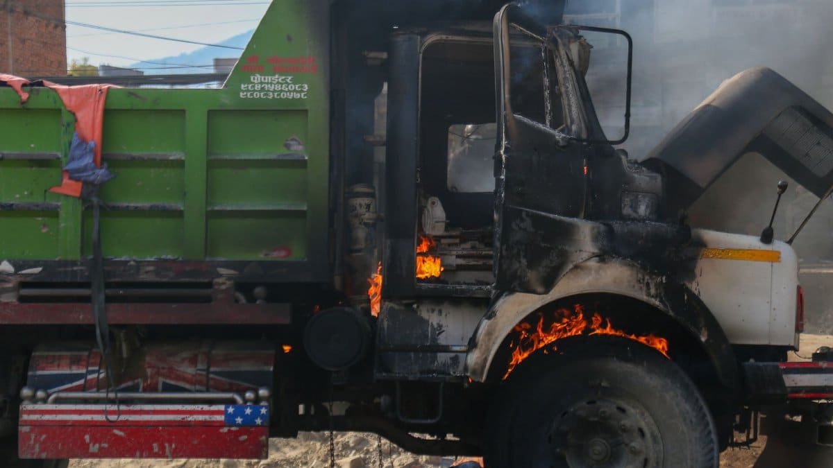 A burning truck creating a striking visual with flames and smoke in an urban setting.