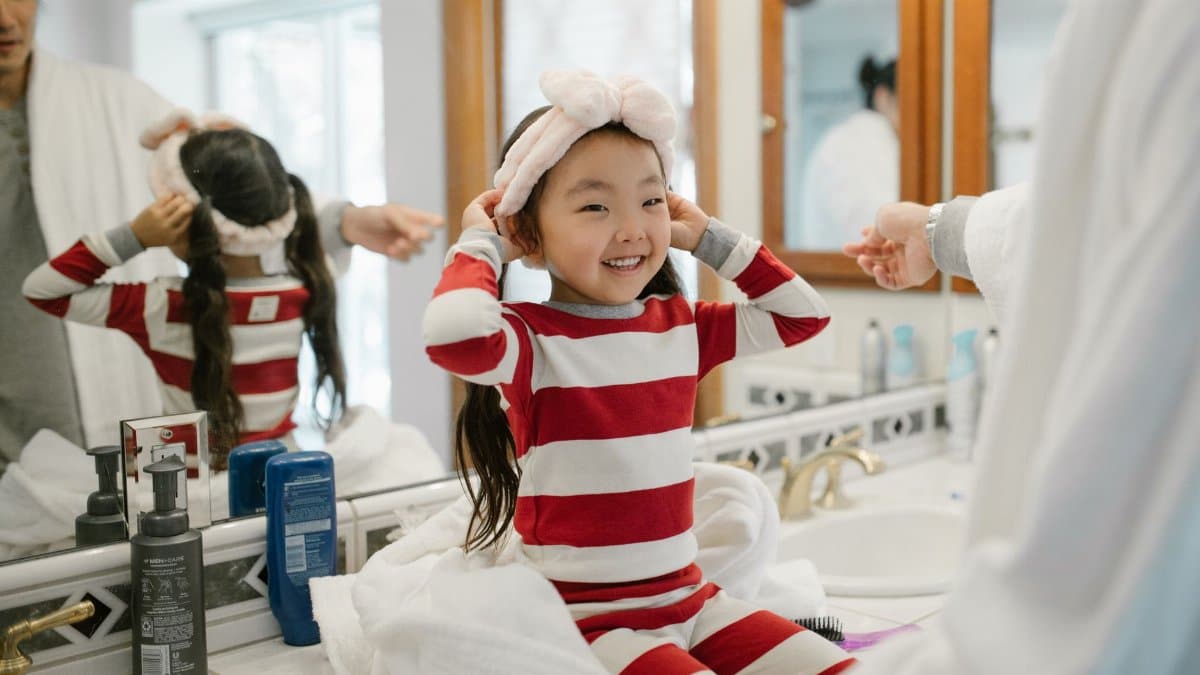 Father and daughter enjoying a cheerful morning routine in their home bathroom.