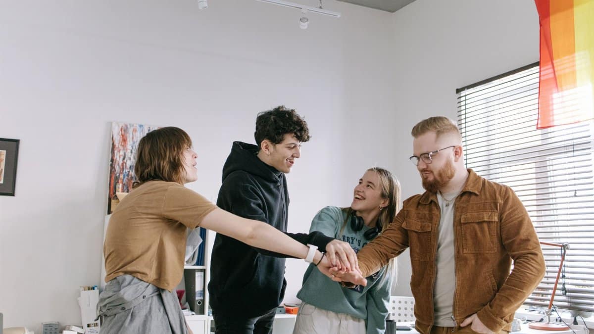 A group of colleagues engaging in team building with hands joined, expressing unity and camaraderie.