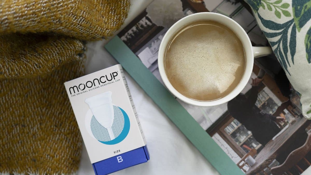A comforting scene with coffee, a book, and a sustainable menstrual cup.