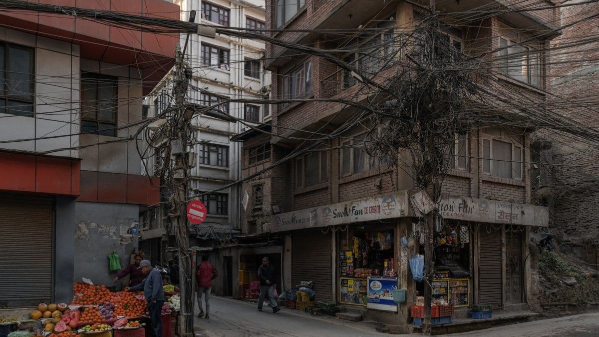Street vendors and pedestrians in a vibrant Kathmandu street scene.
