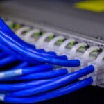 Detailed view of blue ethernet cables connected to a network switch in a data center.