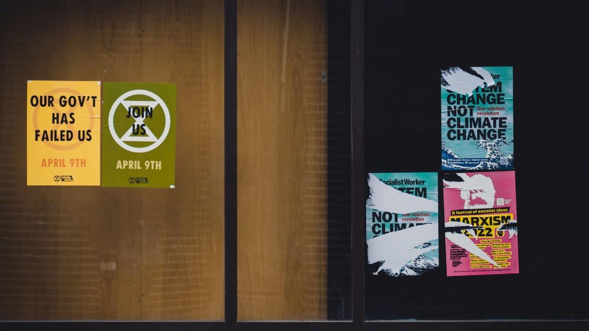 Posters with activism messages displayed on a building window in Oxford, England.