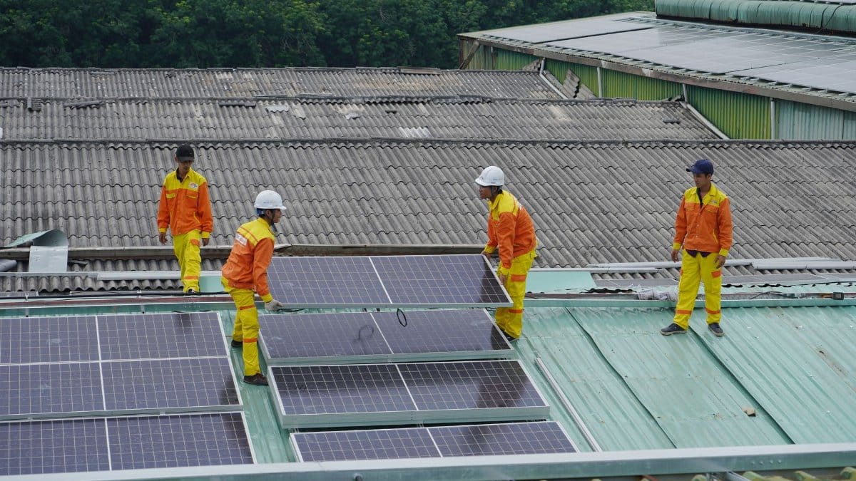 Workers installing solar panels on a roof for sustainable energy solutions.