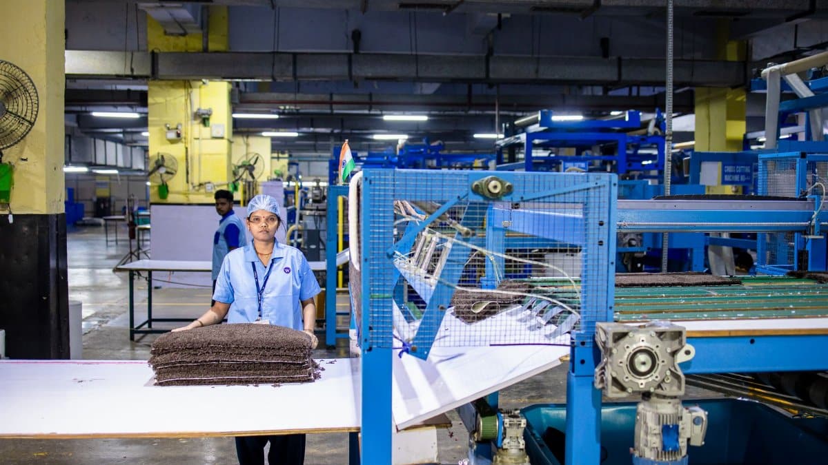 Indian textile worker operating machinery in a factory setting.