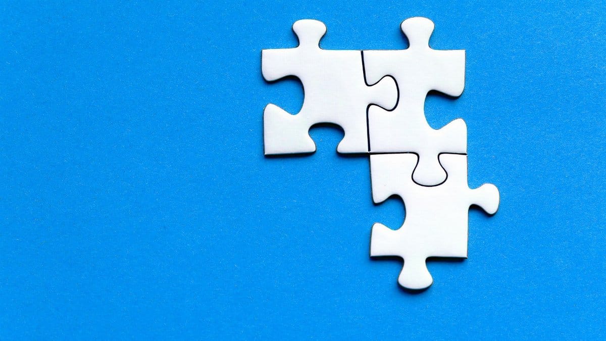 White jigsaw puzzle pieces on a vivid blue background from a top view, perfect for creative concepts.