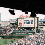 Crowd enjoying a baseball game at Wrigley Field, Chicago's iconic stadium, on a sunny day.