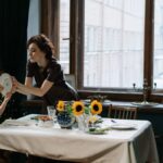 A mother and children engage in a fun meal scene with sunflowers on the table.