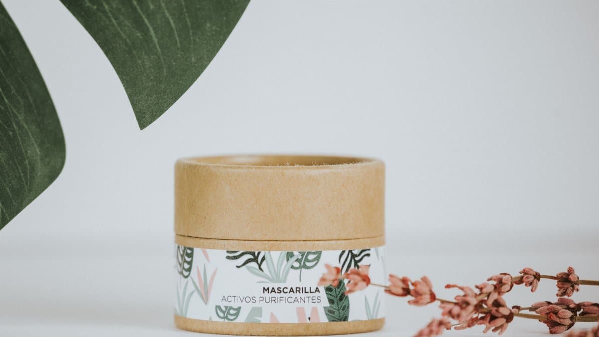 Minimalist shot of a natural cosmetic product in eco-friendly packaging, surrounded by greenery.