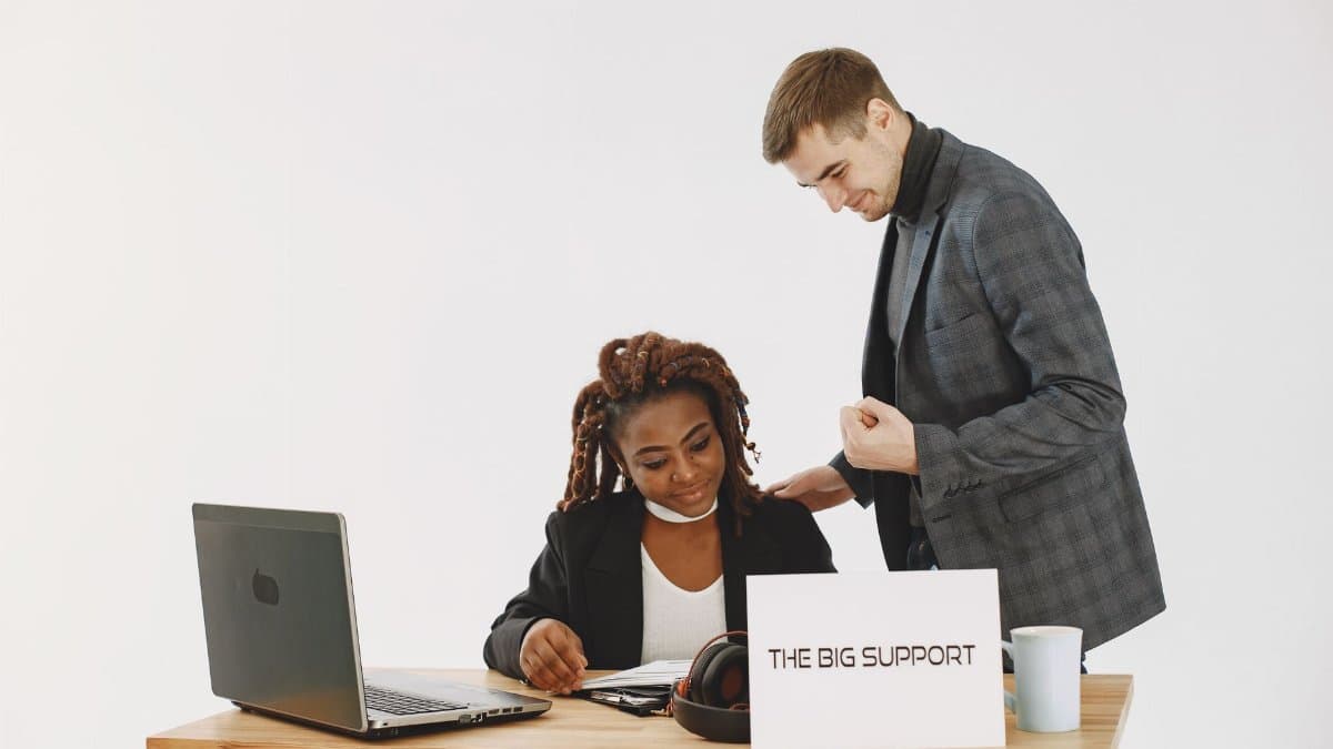 A supportive interaction between colleagues working together on a project in a modern office.