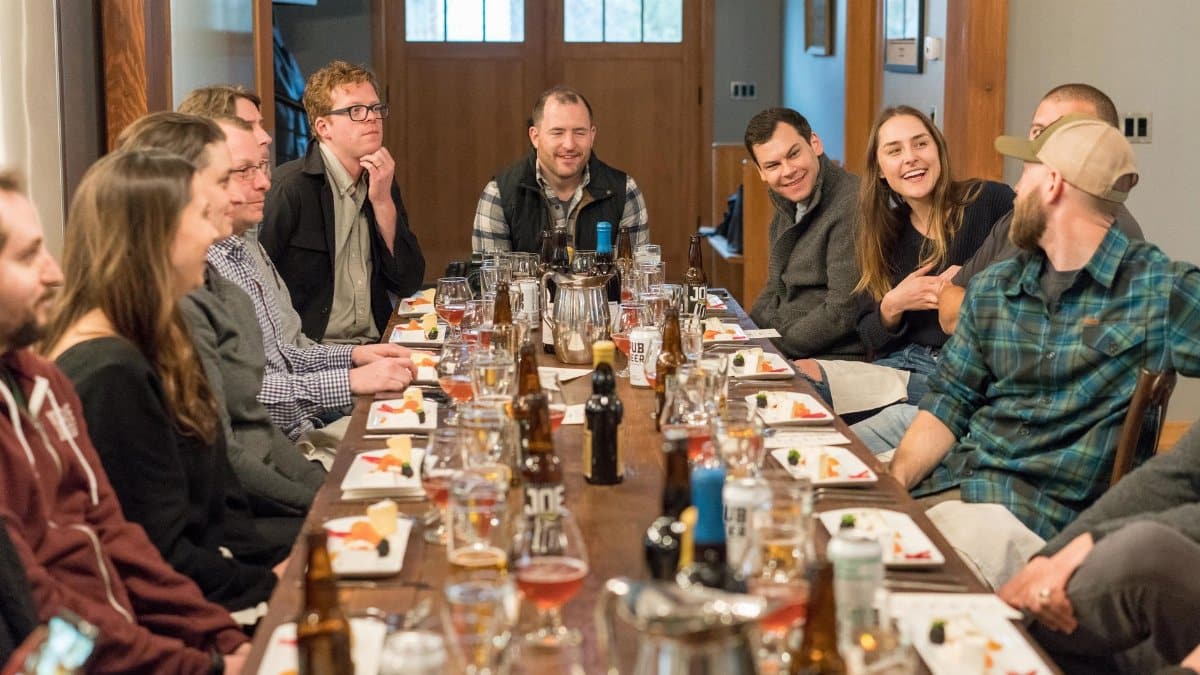 A joyful group of adults enjoying a meal and drinks at a restaurant, fostering communication and friendship.