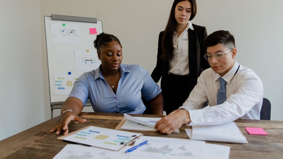 A diverse team discusses business strategies and processes in a modern office space.