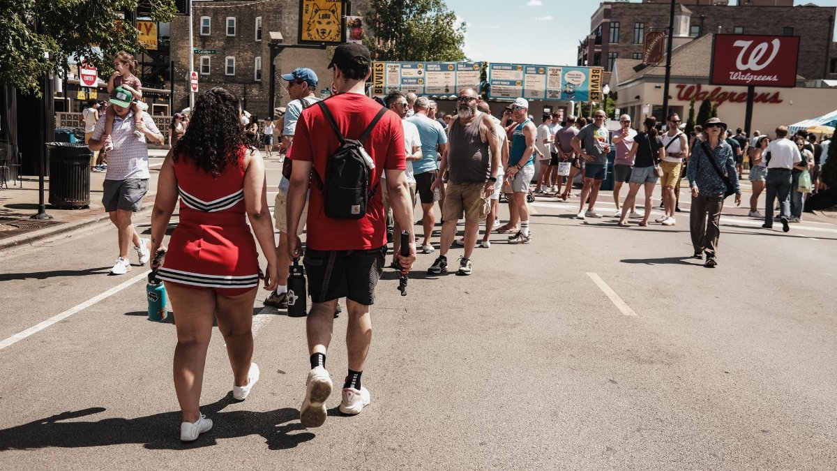 People enjoying a sunlit street event in Chicago, IL. Capture of urban life with a lively crowd.
