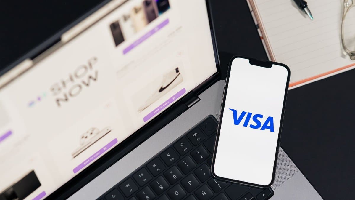 Smartphone displaying VISA on a laptop for online shopping experience.