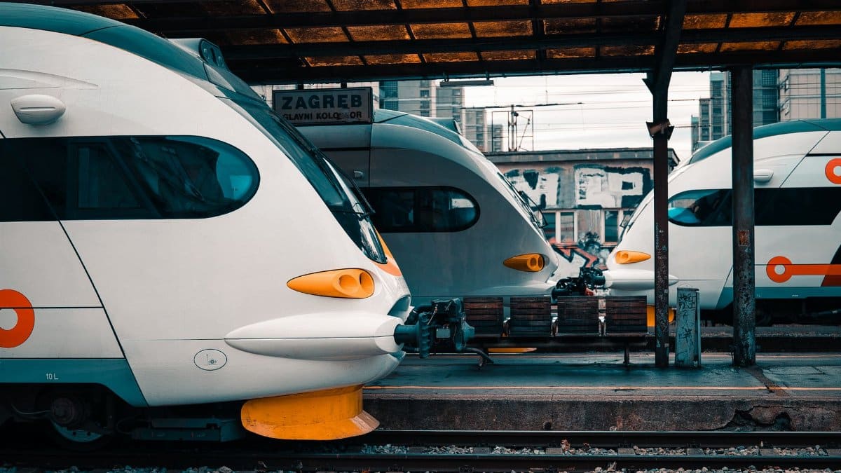 High-speed trains docked at Zagreb station under urban setting.