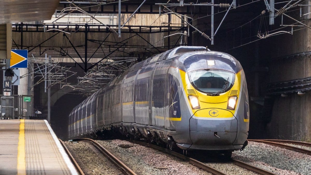 Eurostar high-speed train approaches platform exit from a tunnel, showcasing modern rail travel.