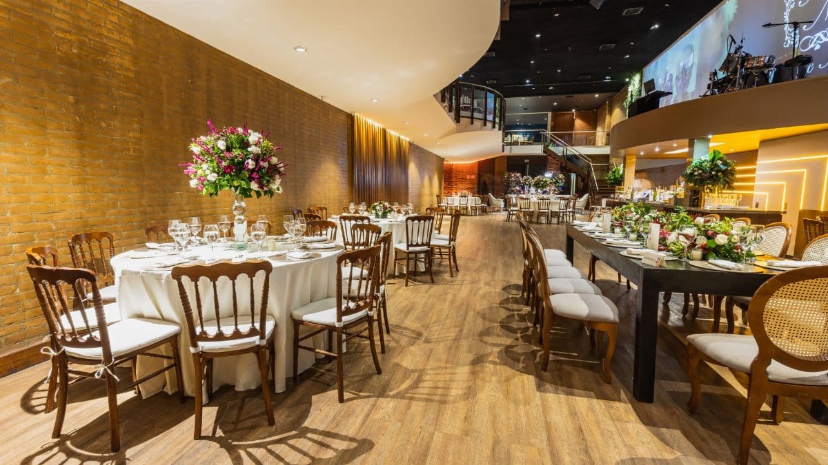 Luxurious wedding hall set for a reception with elegant table arrangements and floral decor.