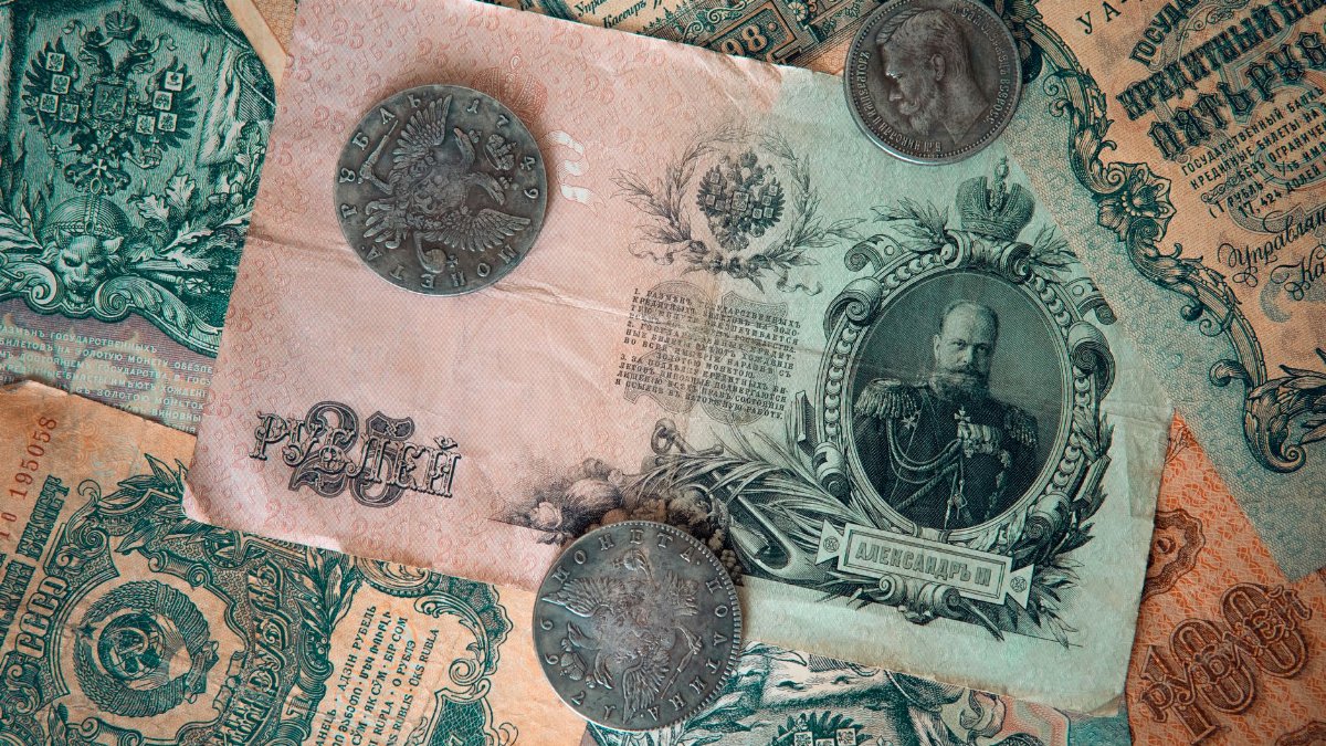 A detailed image of antique Russian banknotes and coins from the Tsarist era, showcasing historical wealth.