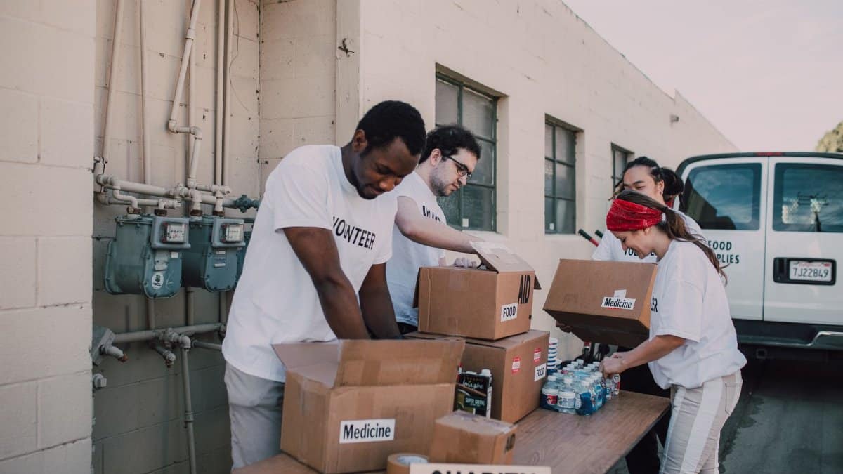 Volunteers sort and prepare donations outdoors for a charitable event.