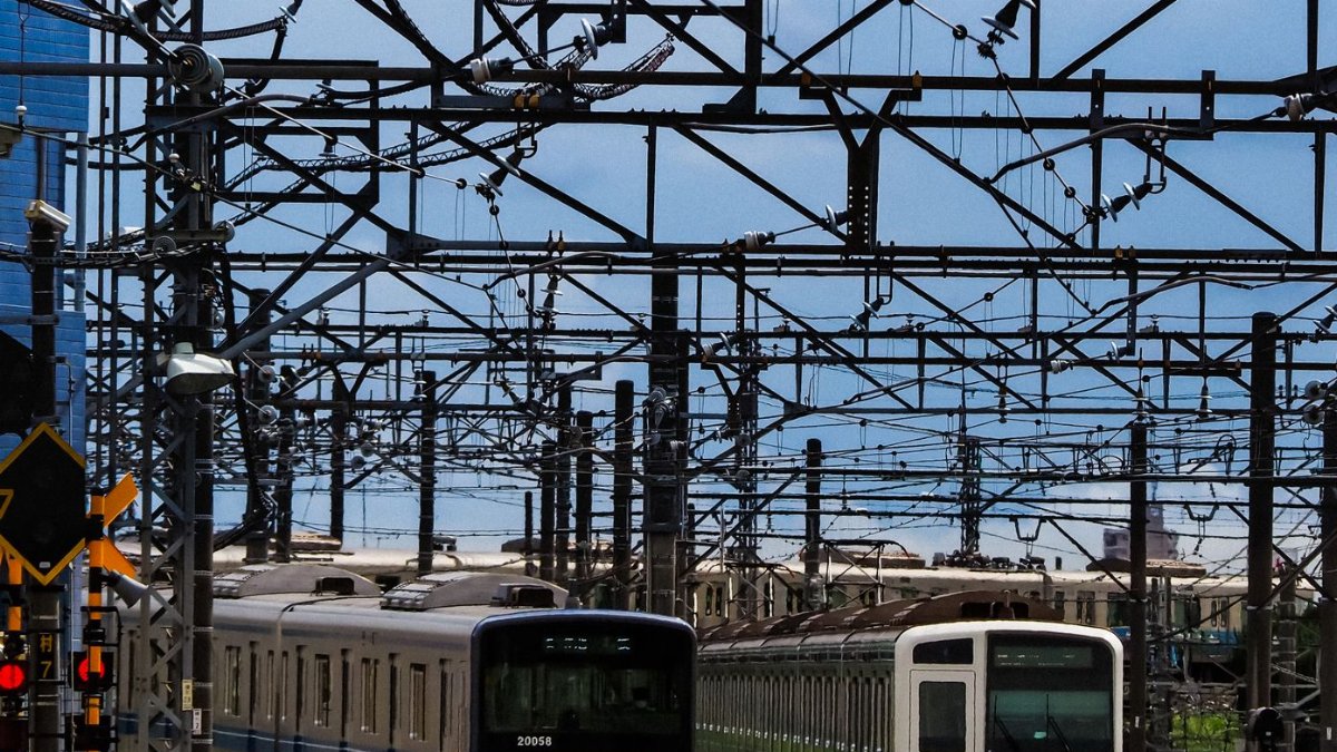 Electric trains on busy tracks in Japan, showcasing infrastructure and transportation.