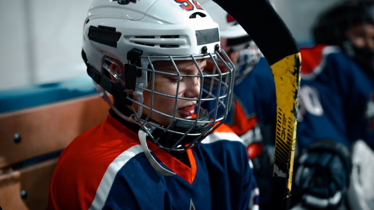 Close-up of a young ice hockey player in full gear, focused and ready for the game.