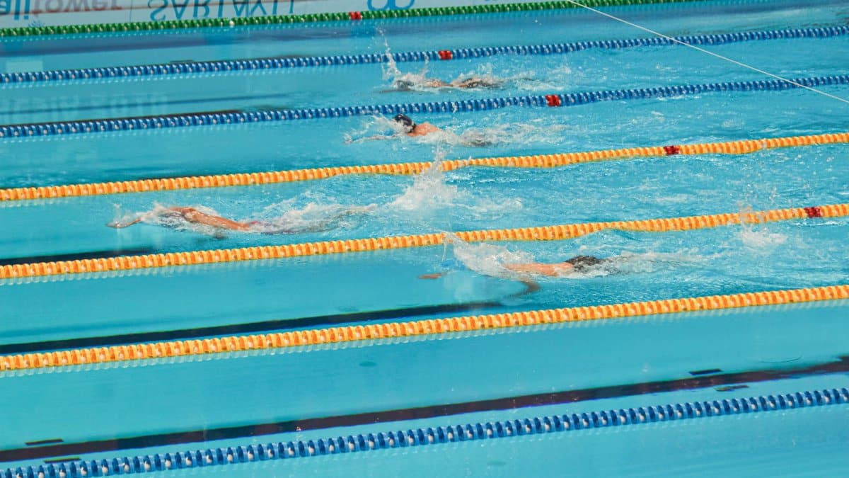 Action-packed swimming competition in Jakarta pool. Swimmers racing in lanes.