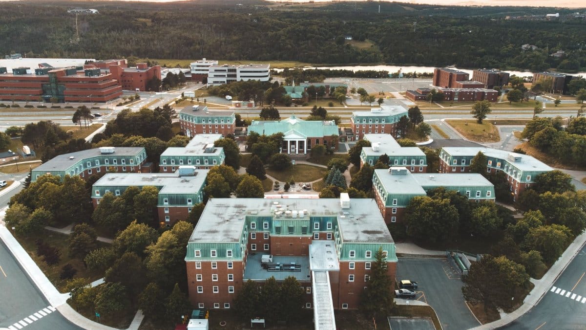 Aerial view of a university campus surrounded by greenery during sunset.