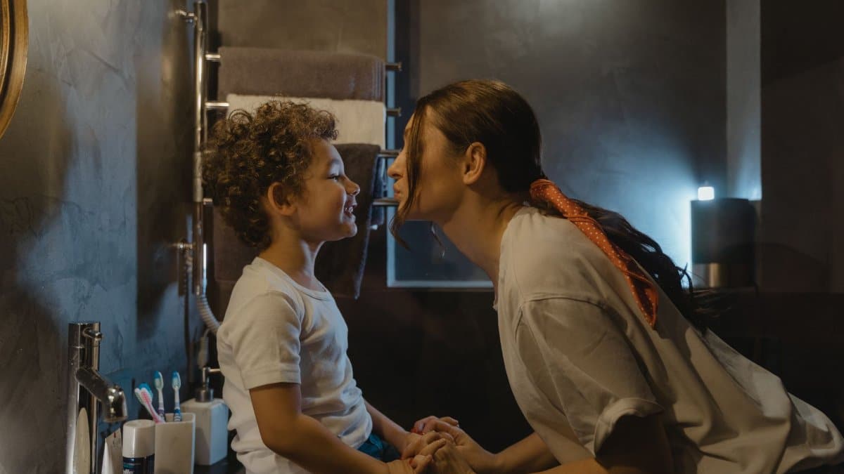 Warm moment between a mother and son in a cozy bathroom setting.