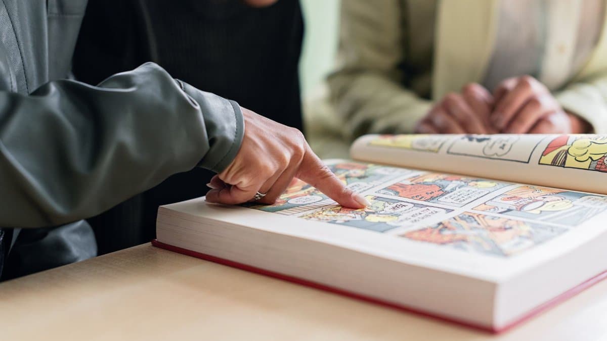 Two individuals focus on reading a colorful comic book, highlighting engaging stories.