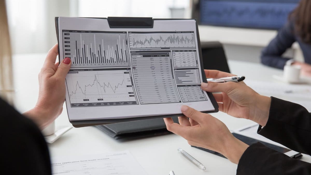 Professionals reviewing data charts on paper during a business meeting.