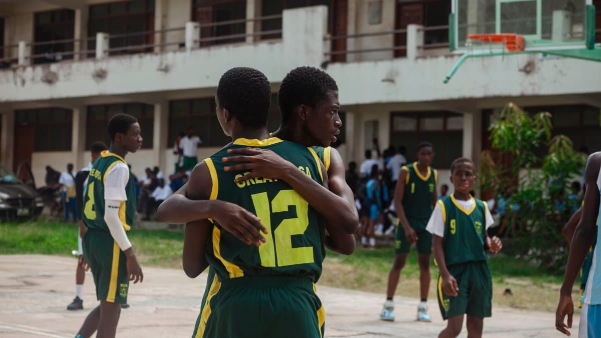 High school basketball players celebrating after scoring. Emphasis on team spirit and youth sports.